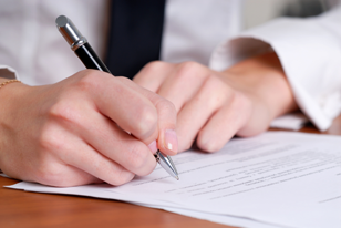 photo of woman's hands signing documents
